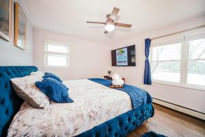 a bedroom with a blue bed and a ceiling fan at Lake House Dream Views and surrounded by nature in Vernon Township