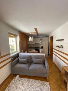 Maison Le Pommier في مورجيكس: غرفة معيشة مع أريكة ومطبخ