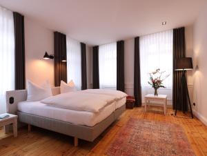 1 dormitorio con 1 cama grande en una habitación con ventanas en Zum Tausendsassa, en Edesheim