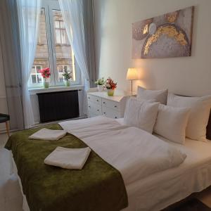 a bedroom with a large bed with two towels on it at Palace Apartment in Budapest