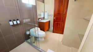 ein Bad mit einem WC und einer Glasdusche in der Unterkunft Samakwā Hotel Boutique in Paipa