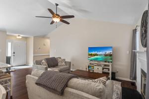 a living room with a couch and a flat screen tv at Time To Relax in Raleigh in Raleigh