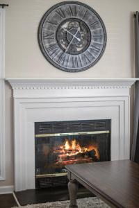 a clock above a fireplace with a fire place at Time To Relax in Raleigh in Raleigh