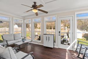 a living room with a ceiling fan and windows at Time To Relax in Raleigh in Raleigh