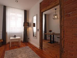 een woonkamer met een tafel en een bakstenen muur bij Zum Tausendsassa in Edesheim