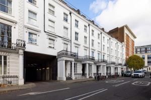 a row of white buildings on a city street at Welcoming Flat with Sauna - Paddington in London