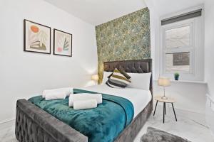 a white bedroom with a large bed with blue blanket at Modern One Bedroom Flat - Sleeps 3 - Near London Zoo, Regent's Park, Camden Market - London NW3 Finchley Road in London