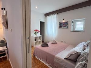 um pequeno quarto com uma cama e uma janela em Central Modern Apartment Near the Beach em Split