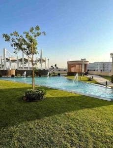 a park with a tree and a building and a fountain at Dubai Sleek & Cozy Space in Dubai