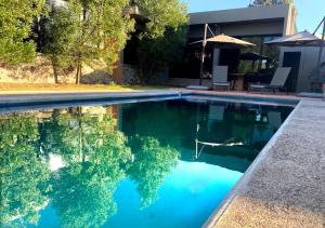 El Pueblito的住宿－Villas del Bosque，一座房子前面的蓝色海水游泳池
