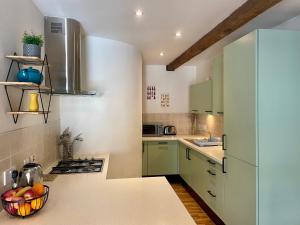 a kitchen with green cabinets and a bowl of fruit on the counter at The Bell Tower in Inverness