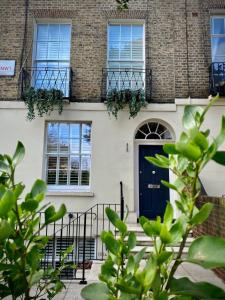 una casa con una puerta azul y ventanas en Luxury 2-Bed Marylebone Georgian House with Private Garden & Office en Londres