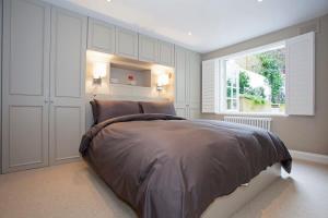 Un dormitorio con una cama grande y una ventana en Luxury 2-Bed Marylebone Georgian House with Private Garden & Office en Londres