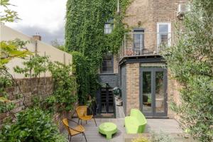a patio with chairs and tables in front of a building at Georgian Townhouse with Sun Terrace & Garden in London
