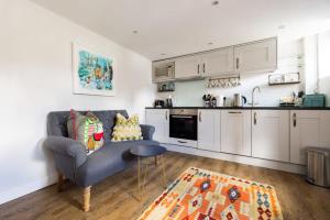 a living room with a couch and a kitchen at The Lavender Folly - Cosy Accommodation Alresford in New Alresford