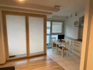 a kitchen with sliding glass doors and a table with a computer at 3 mins to the metro/train, 5 mins to city centre! in Warsaw