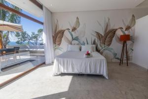 een slaapkamer met een wit bed en een muurschildering bij VILAS de LUXO in Gamboa