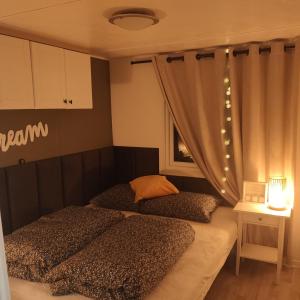 2 Einzelbetten in einem Zimmer mit Fenster in der Unterkunft Chalet Olive im Park De Veerstal in Lathum