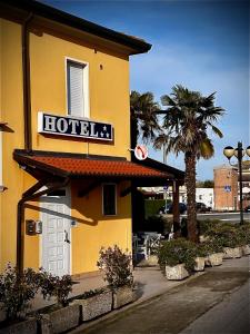 un hôtel avec un panneau sur le côté d'un bâtiment dans l'établissement Hotel Ponte Molo, à Porto Tolle