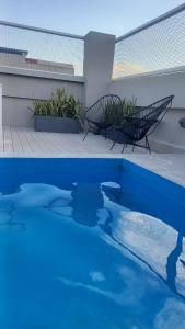 een blauw zwembad met twee banken op een patio bij Lavalle 665 in San Miguel de Tucumán