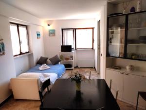 Fulvia's cozy apartment with terrace في مونتيروسّو ال ماري: غرفة معيشة فيها سرير وطاولة فيها