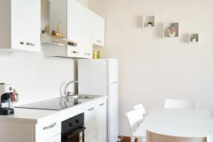 eine weiße Küche mit einer Spüle und einem Kühlschrank in der Unterkunft A 2 passi dal mare in Zona Centralissima in Pescara