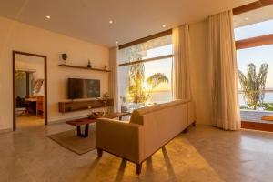 甘博阿的住宿－VILAS de LUXO，带沙发和大窗户的客厅