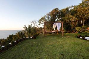 甘博阿的住宿－VILAS de LUXO，背景海洋的板凳