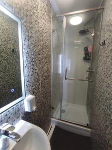 a bathroom with a shower and a sink and a shower at Sunny Hostel Nurmakova in Almaty