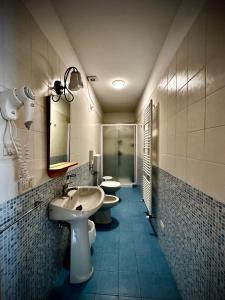 La salle de bains est pourvue de 2 lavabos et de 2 toilettes. dans l'établissement Hotel Ponte Molo, à Porto Tolle