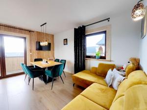 a living room with a yellow couch and a table at Osada pod Giewontem in Czerwienne