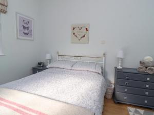 a bedroom with a bed and a dresser at Foxholes Lodge in Settle