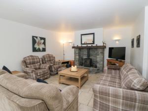 a living room with two couches and a fireplace at Rock Lawn Cottage in Glanbannoo Upper