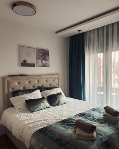 ein Schlafzimmer mit einem großen Bett und einem Fenster in der Unterkunft Helena Lux apartman Zlatibor in Zlatibor