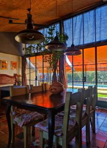a dining room with a table and chairs and windows at Departamento los lapachos in Villa Allende