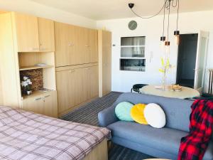 a living room with a blue couch and a kitchen at Zeezicht Studio Alisa in Blankenberge