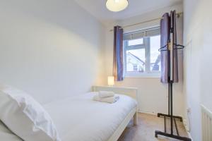 - une chambre avec un lit blanc et une fenêtre dans l'établissement Comfortable 3 bed house in Chelmsford, à Chelmsford