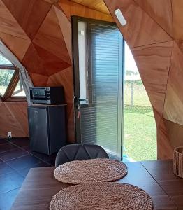 タクアレンボーにあるDomo guidaíのテーブルと椅子、窓が備わる客室です。