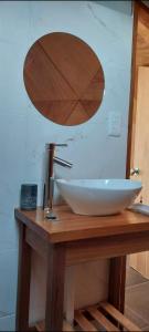 a sink on a wooden table with a mirror at Domo guidaí in Tacuarembó