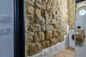 un muro in pietra in bagno con lavatrice di Happy House a Costa di Mezzate