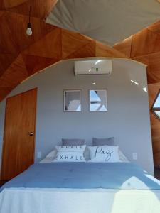 um quarto com uma cama grande e um tecto em madeira em Domo guidaí em Tacuarembó