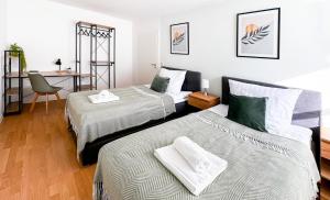 a bedroom with two beds and a desk with a chair at Zentrum, 3 Zi, Tiefgarage, smart TV, WLAN, Netflix, Küche in Augsburg