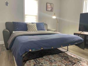 1 cama con edredón azul en un dormitorio en Modern Home in Leeds & Thousand Islands, en Lansdowne
