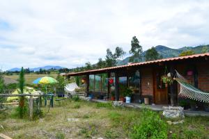 una casa con una hamaca delante en Casa de campo independiente sector Chachimbiro –Urcuqui en Ibarra