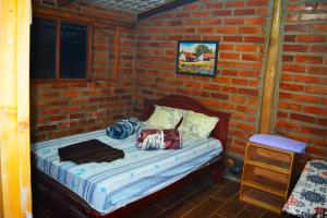 a bedroom with a bed in a brick wall at Casa de campo independiente sector Chachimbiro –Urcuqui in Ibarra