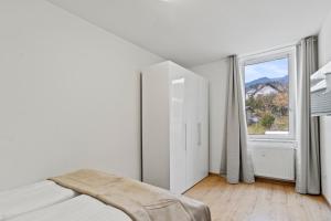ein weißes Schlafzimmer mit einem Bett und einem Fenster in der Unterkunft Natur & Komfort in der Nähe von Semmering in Mürzzuschlag