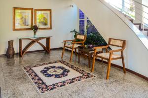 ein Wohnzimmer mit Stühlen, einem Tisch und einem Teppich in der Unterkunft Apto confortável próximo a Praia do Forte CEE202 in Cabo Frio