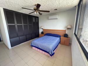 - une chambre avec un lit et un ventilateur de plafond dans l'établissement Depa Roca Sola Acapulco Costera, à Acapulco