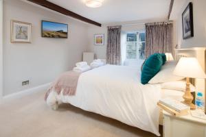 a bedroom with a large white bed and a desk at Castle Retreat - luxury apartment opposite Alnwick Castle in Alnwick