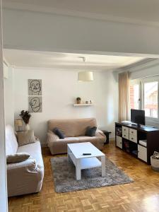 a living room with a couch and a table at Apartamento en Getxo. Cercano al puerto viejo in Getxo